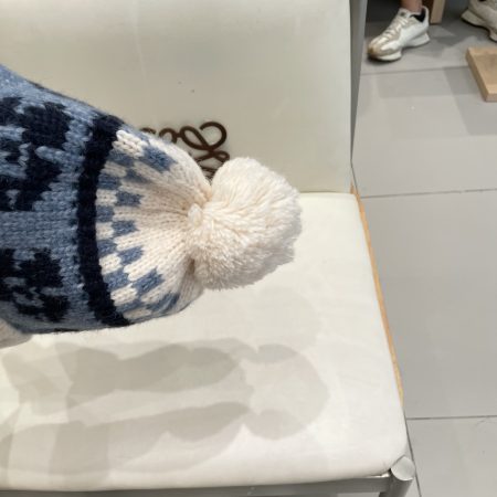 Original Moncler Nordic-style knitted hat with ear protection and pom-poms.